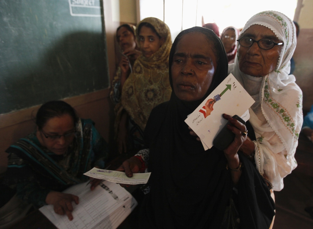 women voters one c holding an election flyer for the pakistan people 039 s party ppp wait for their turn to cast their vote at a polling station in karachi may 11 2013 photo reuters