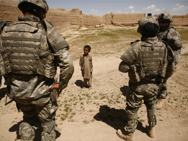 an afghan boy looks at us soldiers as they patrol a village near the town of makkor southwest of kabul april 20 2007 photo reuters