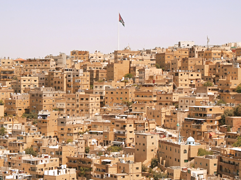 the jordanian flag flies high above the city of amman photo myra khan