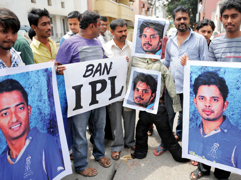 demonstrators hold posters and shout slogans against indian cricketers in bangalore during a protest against their alleged involvement in match fixing photo afp