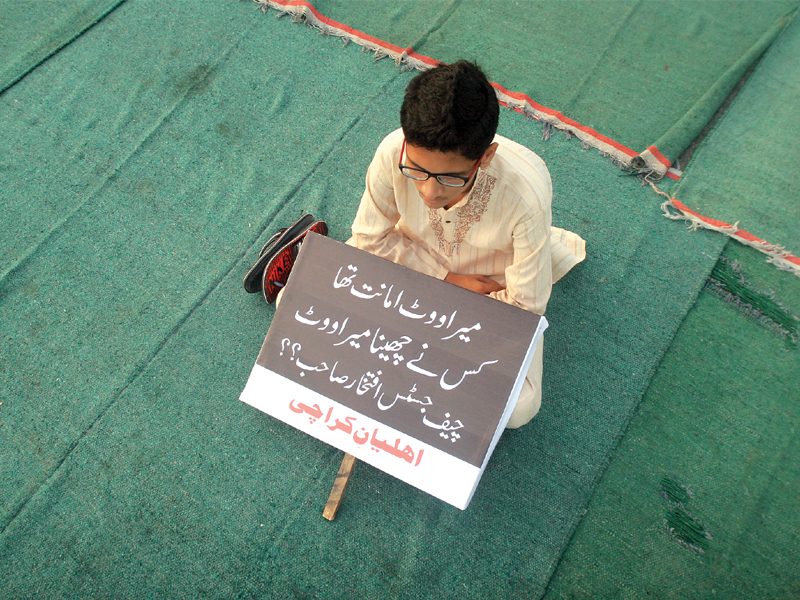 a boy who participated in jamaat e islami s protest at mazar e quaid on friday holds a sign saying people s right to vote was snatched photo athar khan express