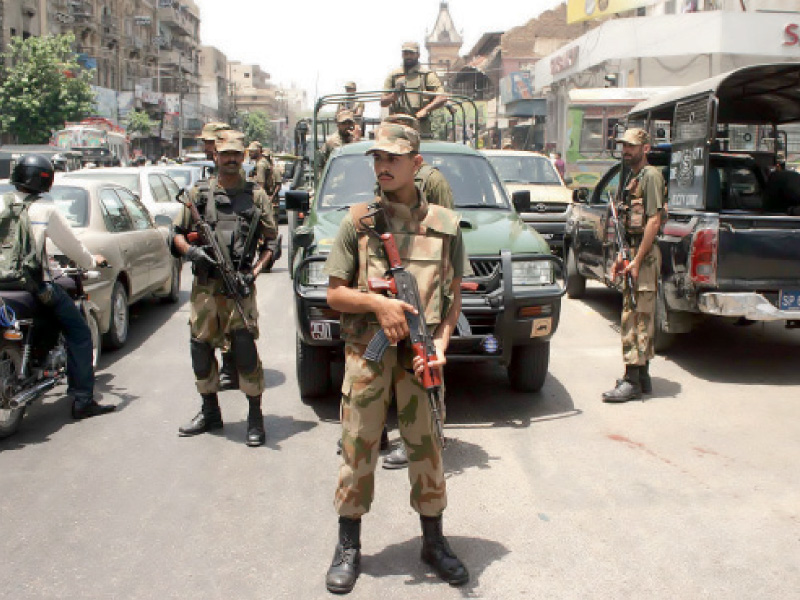 a soldier stands guard on a road near new haji camp on saturday a day before re polling at some polling stations of na 250 photo inp