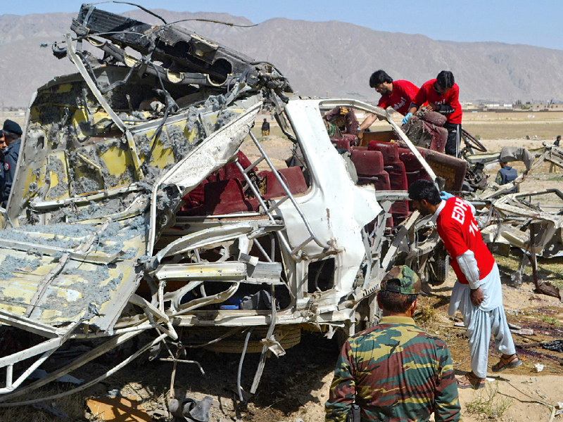 volunteers search the wreckage of a vehicle following a bomb attack on the outskirts of quetta photo afp