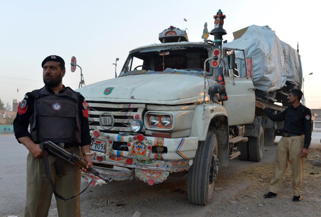 policemen stand guard beside a truck carrying a nato forces vehicle after an attack by gunmen on the outskirts of peshawar on may 16 2013 photo afp file policemen stand guard beside a truck carrying a nato forces vehicle after an attack by gunmen on the outskirts of peshawar on may 16 2013 photo afp file