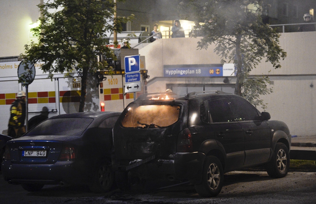 firemen extinguish a burning car in the stockholm suburb of tensta after youths rioted in few different suburbs around stockholm and sweden on may 24 2013 photo afp