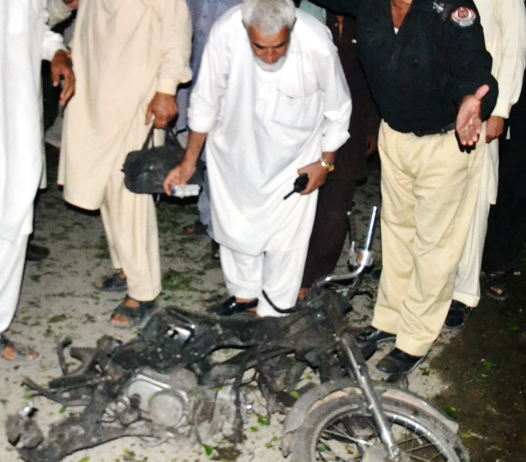 bomb disposal officials inspect the motorcycle used in the bombing photo sameer raziq