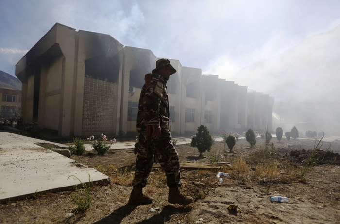 an afghan security officer walks in front of a panjshir government building after an attack by insurgents in panjshir province may 29 2013 photo reuters