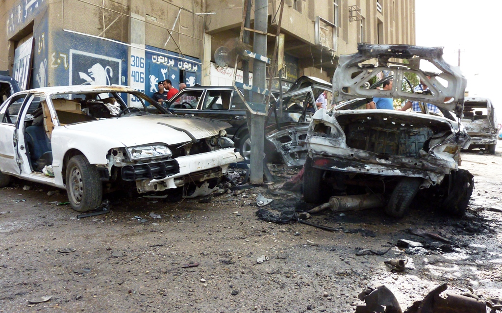 destroyed cars sit at the site of a blast in baghdad on may 30 2013 photo afp