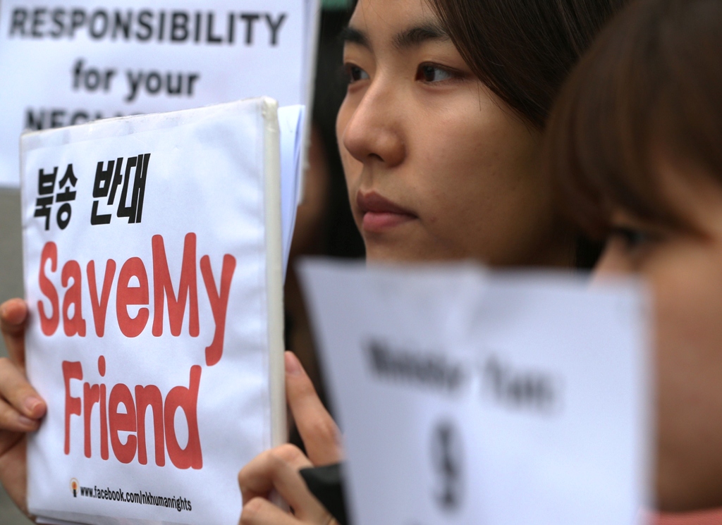 this picture taken on may 29 2013 shows an activist of a civic group for north korean refugees holding up a placard during a rally urging china to stop repatriating north korean defectors outside the foreign ministry in seoul photo afp