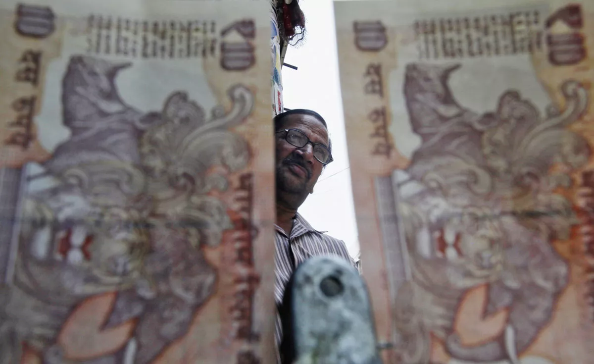 a roadside currency exchange vendor is pictured through indian rupee notes in the old quarters of delhi may 31 2013 photo reuters a roadside currency exchange vendor is pictured through indian rupee notes in the old quarters of delhi may 31 2013 photo reuters