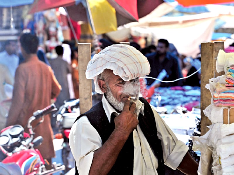 a vendor takes a drag from his cigarette on world no tobacco day photo afp