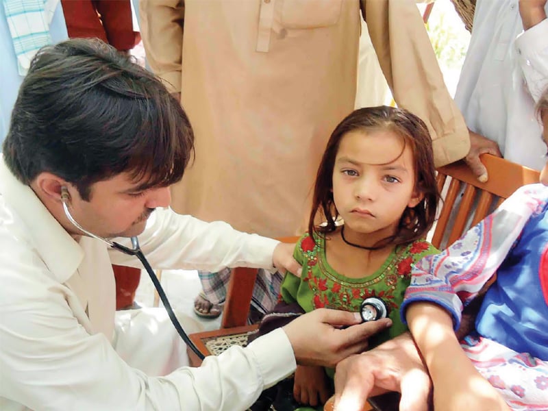 a doctor examines a girl who fell sick after drinking water from a hand pump installed at khabri bhit primary school near salehpat sukkur over 30 other students and a teacher also fell ill after drinking water photo ppi
