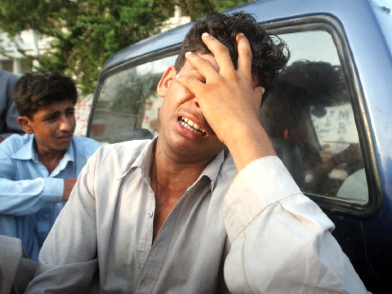 the brothers of 22 year old ghulam haider who was shot dead on tuesday allegedly by rangers personnel mourn his death outside jinnah hospital s mortuary photo athar khan express