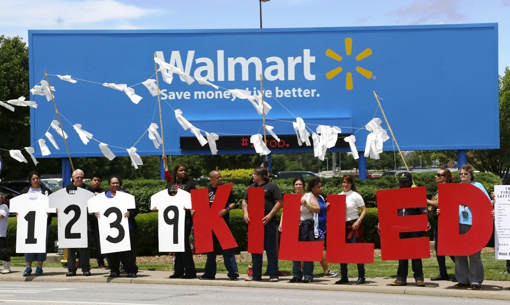 protesters hold up a sign commemorating those killed in recent clothing factory tragedies in bangladesh outside wal mart stores inc headquarters in bentonville arkansas june 5 2013 photo reuters