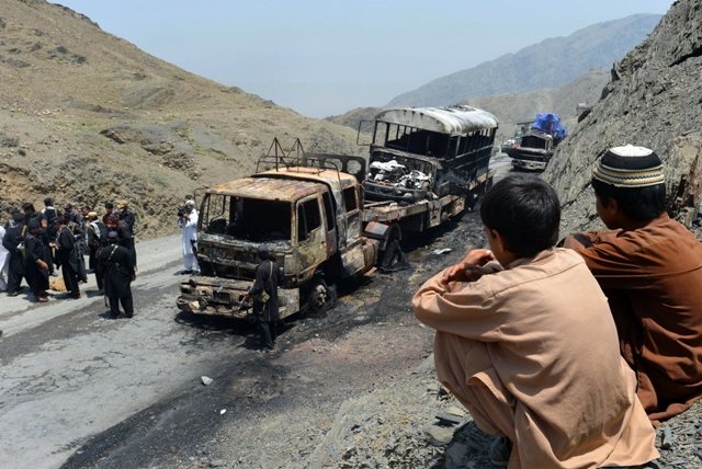 security personnel gather beside torched nato supply trucks after an attack by armed militants in khyber district on june 10 2013 photo afp