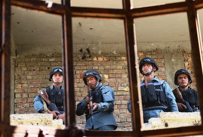 afghanistan policemen stand guard in a building which was used for attack on kabul airport in kabul on june 10 2013 photo afp