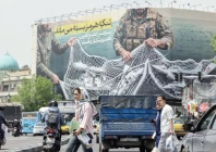 iranian walks past a giant billboard reading the strait of hormuz remains closed at revolution square in tehran photo afp