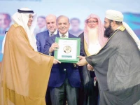 prime minister shehbaz sharif presents shields for the saudi leadership to ambassador of saudi arabia to pakistan nawaf bin saeed ahmad al malkiy at the sixth paigham e islam conference photo app
