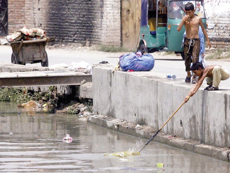 children collect garbage from a sewage drain to earn a living and support their families in bahar colony according to sparc a national survey conducted in 2010 revealed 12 million child labourers were working in the country photo ppi