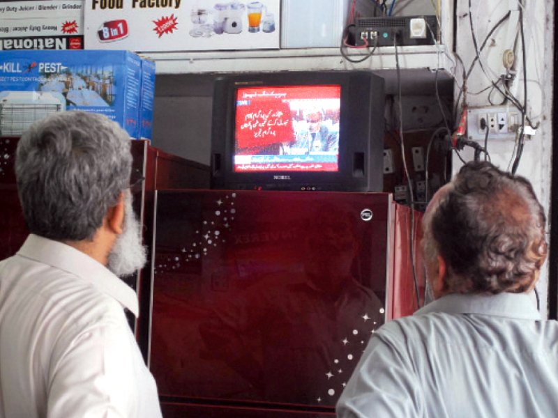 onlookers watch a live telecast of the federal budget for fiscal year 2013 14 photo inp