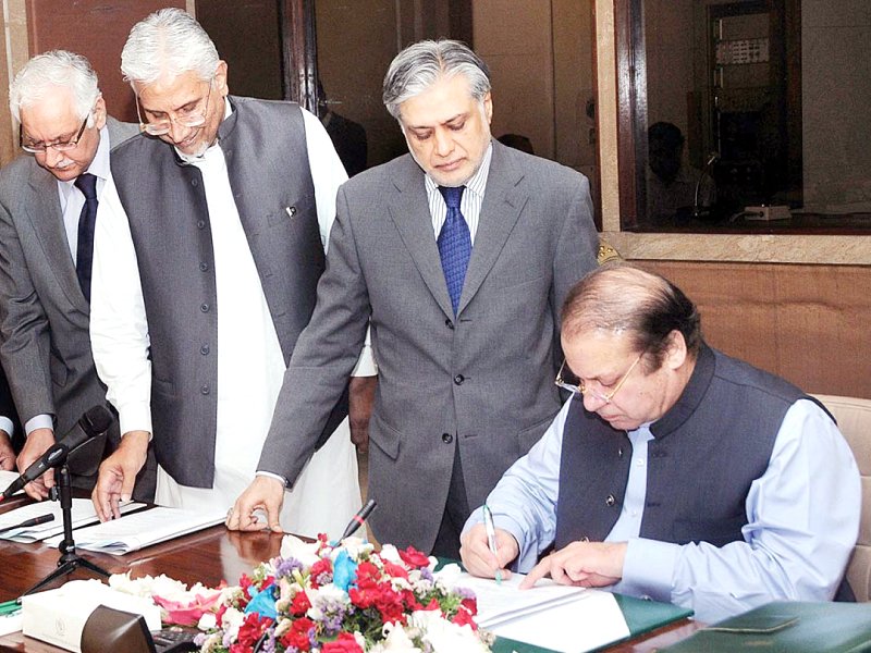 prime nawaz sharif signs the budget document as finance minister ishaq dar looks on photo app