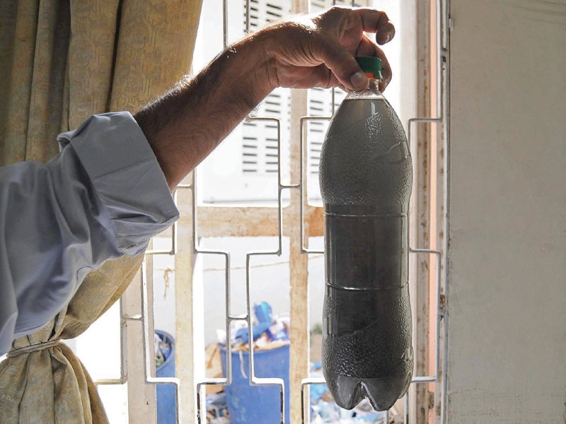 a resident of north karachi holds up a bottle full of tap water inside his home research has led health experts to believe that water supplied to a lot of areas in the city isn t fit for consumption photo file