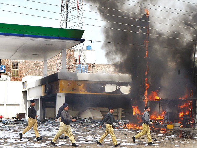 a file photo of a policemen walking across a petrol station gutted in a violent protest related to power issues photo afp