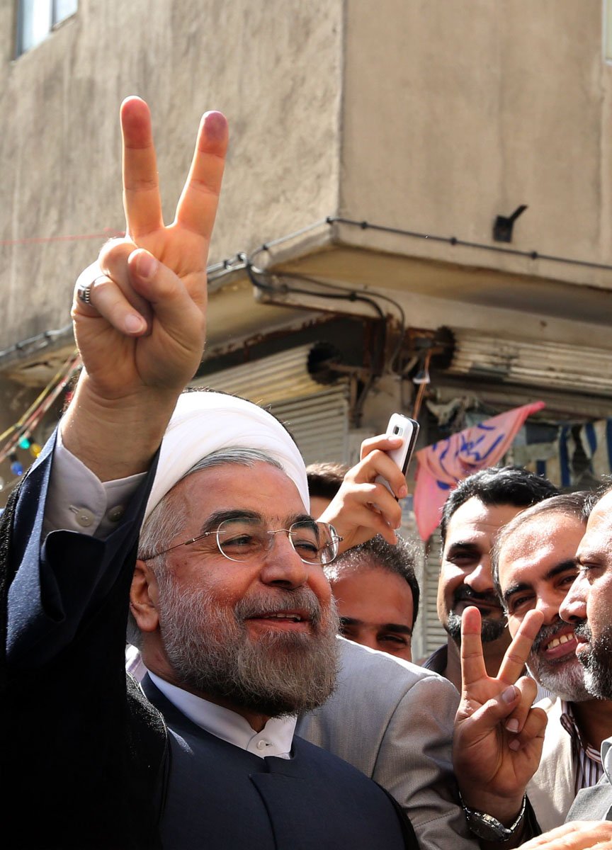 a picture taken on june 14 2013 shows iranian moderate presidential candidate hassan rowhani flashing the sign for victory as he leaves a polling station after voting photo afp