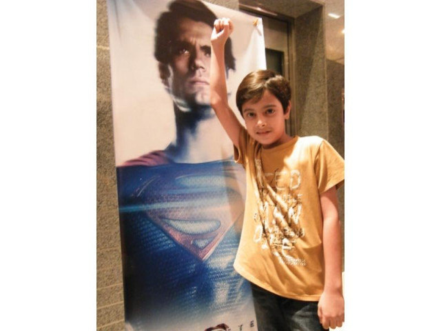 a boy poses in front of the movie poster photo express a boy poses in front of the movie poster photo express