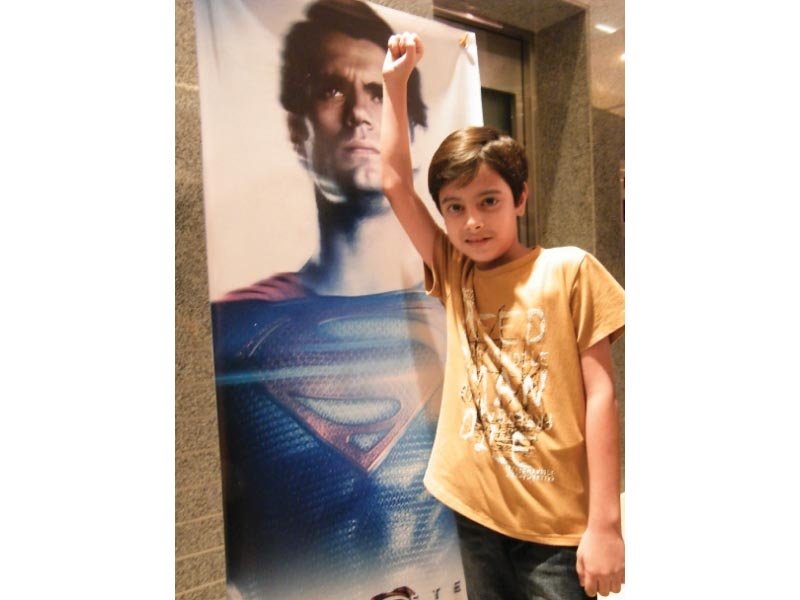 a boy poses in front of the movie poster photo express