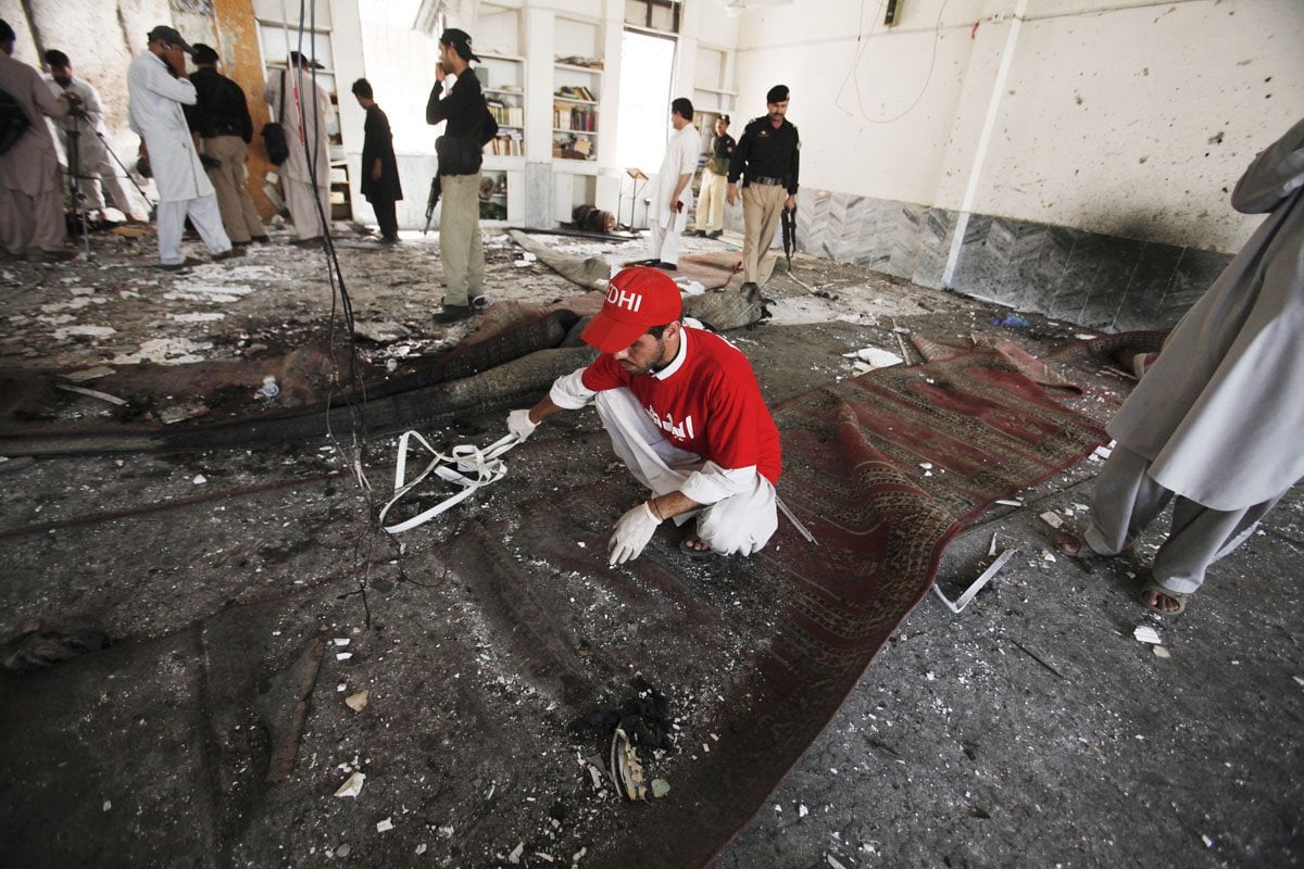 a rescue worker collects evidence from the site of a suicide bomb attack at a shia mosque in peshawar june 21 photo reuters