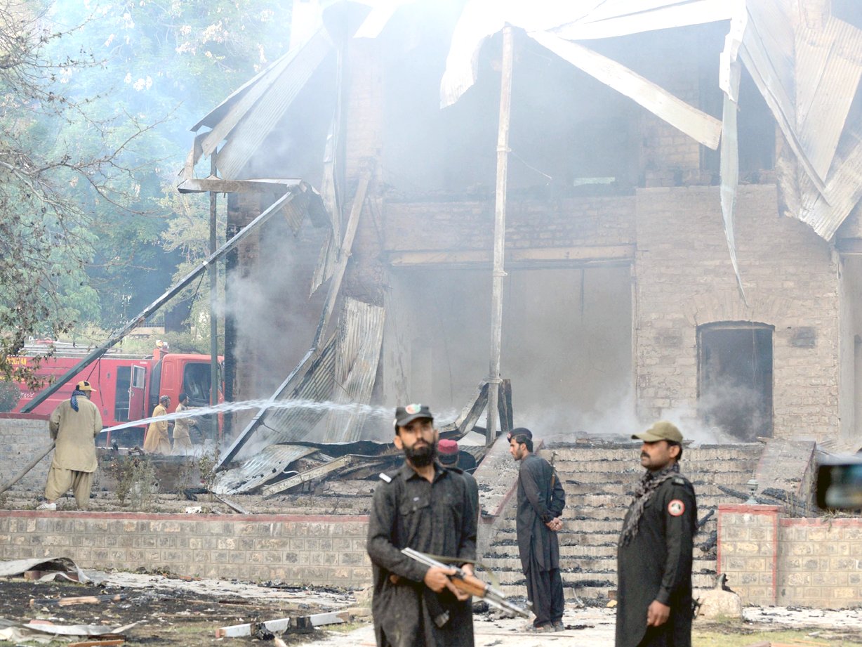 pakistani security personnel look on as firefighters extinguish the blaze at the last residency of the founder of pakistan photo afp