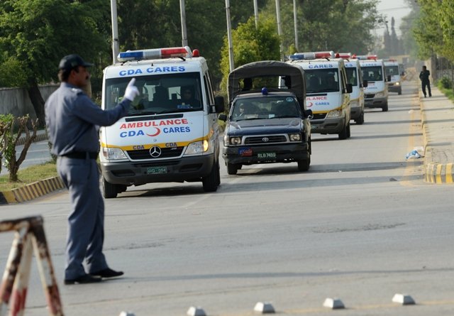 pakistani police escort ambulances carrying the coffins of foreign tourists as they come out from chaklala air base in rawalpindi on june 23 2013 photo afp