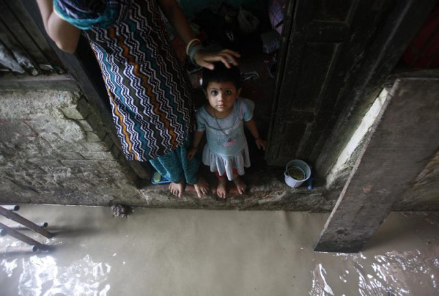 a child watches while standing on the doorstep of her house next to a flooded alley photo reuters a child watches while standing on the doorstep of her house next to a flooded alley photo reuters