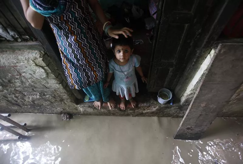 a child watches while standing on the doorstep of her house next to a flooded alley photo reuters a child watches while standing on the doorstep of her house next to a flooded alley photo reuters