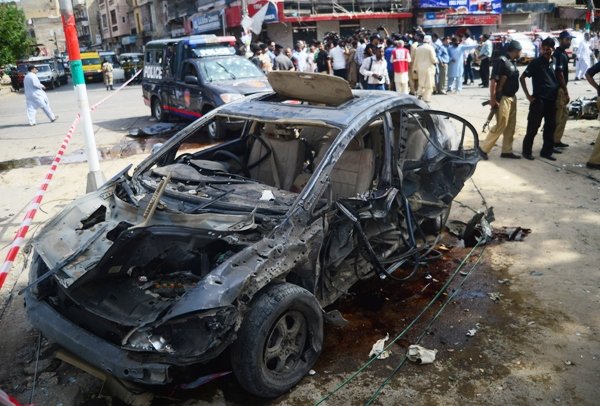 security personnel gather around the car of maqbool baqir a senior judge that was injured in a bomb attack in karachi on june 26 2013 photo afp