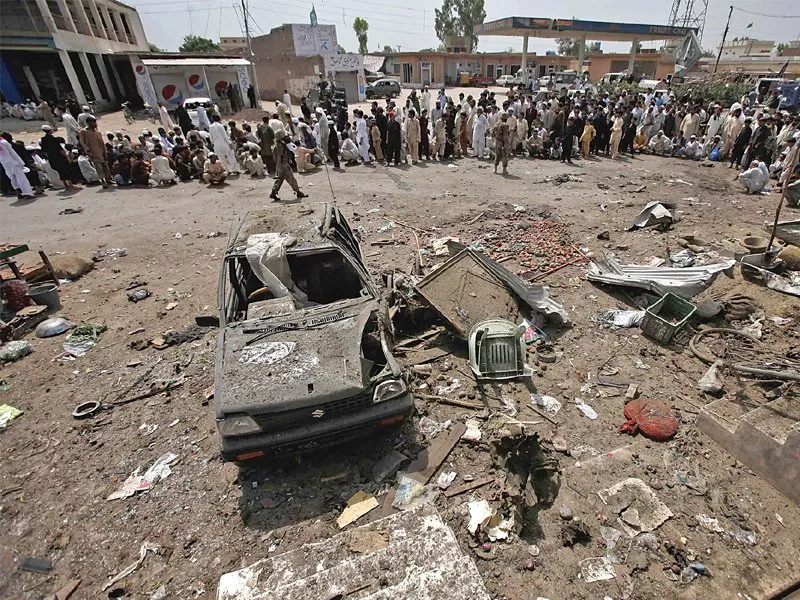 crowd gathers near the wreckage of a car used in a bomb attack on a convoy of paramilitary frontier corps in peshawar photo afp crowd gathers near the wreckage of a car used in a bomb attack on a convoy of paramilitary frontier corps in peshawar photo afp