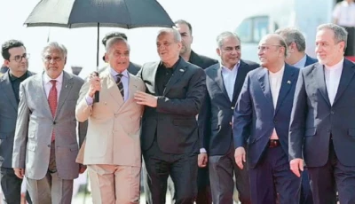 prime minister sharif holds an umbrella over visiting iranian president dr masoud pezeshkian as he and president asif ali zardari extend a cordial welcome upon his arrival at nur khan airbase photo ppi