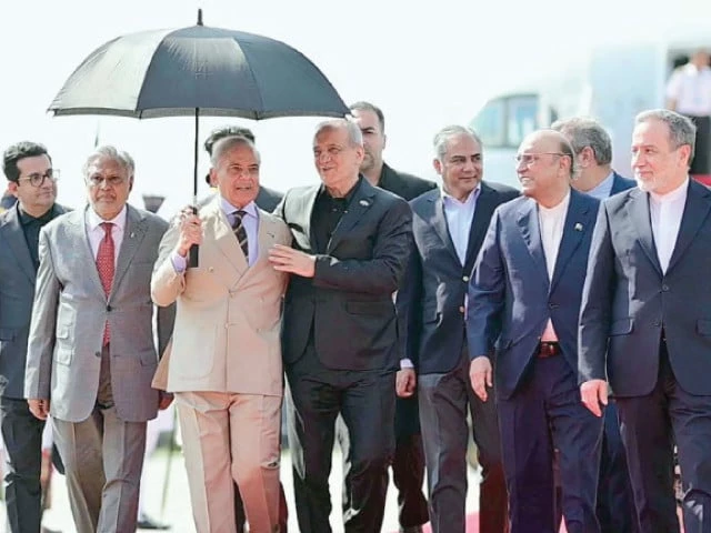 prime minister sharif holds an umbrella over visiting iranian president dr masoud pezeshkian as he and president asif ali zardari extend a cordial welcome upon his arrival at nur khan airbase photo ppi prime minister sharif holds an umbrella over visiting iranian president dr masoud pezeshkian as he and president asif ali zardari extend a cordial welcome upon his arrival at nur khan airbase photo ppi
