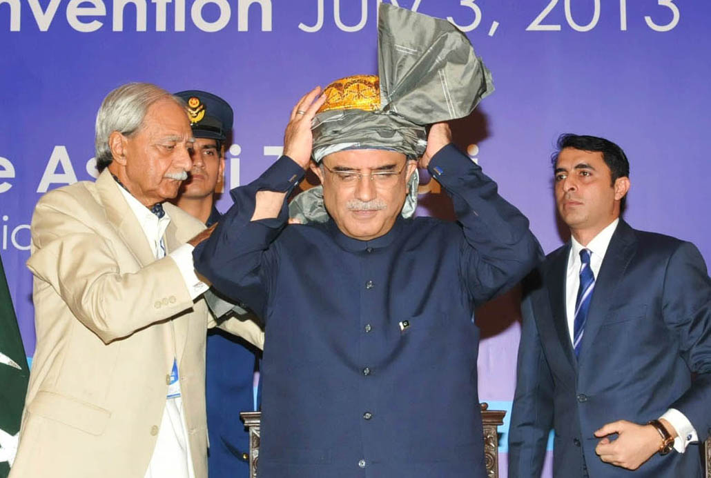 ceo shaheed bhutto foundation khalid m shafi presenting a traditional tribal turban to president zardari during fata convention at the presidency photo pid