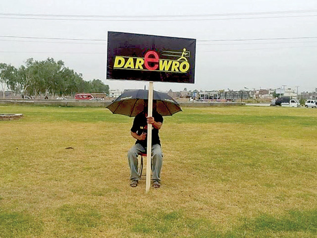 labourers stand around the busy squares of the city holding banners with dar e waro we will deliver written on them photo express labourers stand around the busy squares of the city holding banners with dar e waro we will deliver written on them photo express