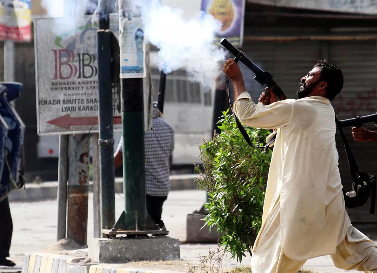 policeman in civilian clothes resorts to aerial firing to disperse protesters in lyari photo nni policeman in civilian clothes resorts to aerial firing to disperse protesters in lyari photo nni