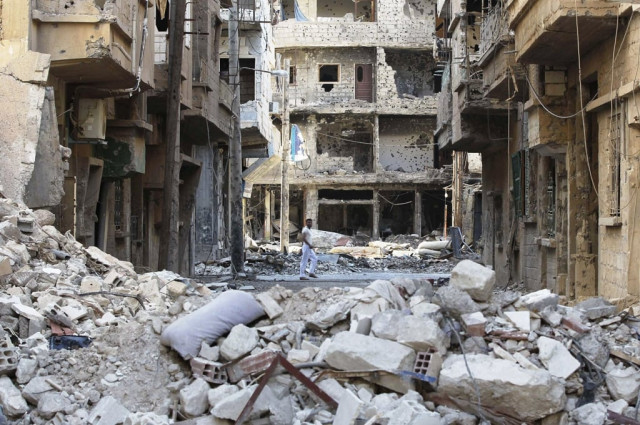 a man walks along a damaged street filled with debris in deir al zor july 5 2013 photo reuters a man walks along a damaged street filled with debris in deir al zor july 5 2013 photo reuters