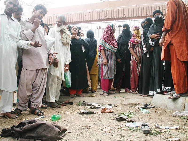 two women lost their lives in monday s stampede during a ration distribution in gulshan e iqbal the other women are gathered around their shoes and other belongings photo online two women lost their lives in monday s stampede during a ration distribution in gulshan e iqbal the other women are gathered around their shoes and other belongings photo online