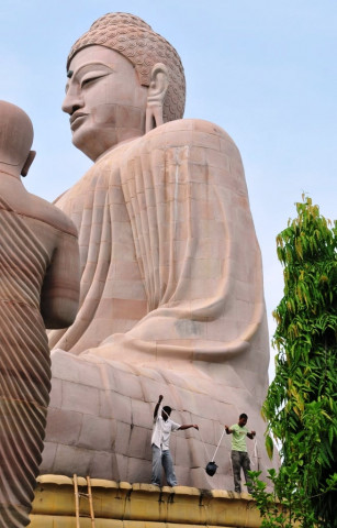 in this photograph taken on july 7 2013 indian bomb disposal personnel recover an unexploded bomb from the great statue of lord buddha following eight low intensity serial blasts at the bodh gaya temple complex in bodh gaya photo afp