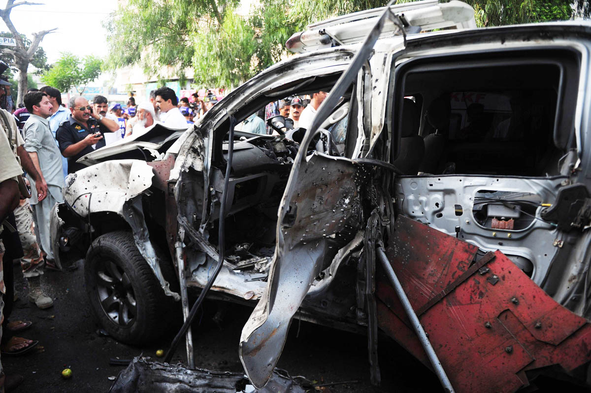 pakistani security officials inspect the wreckage of a vehicle at the site of a bomb blast in karachi on july 10 2013 photo afp