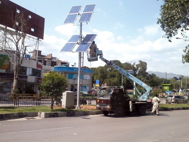 cda workers positioning the solar panels on a pylon at aabpara chowk islamabad photo waqas naeem express cda workers positioning the solar panels on a pylon at aabpara chowk islamabad photo waqas naeem express