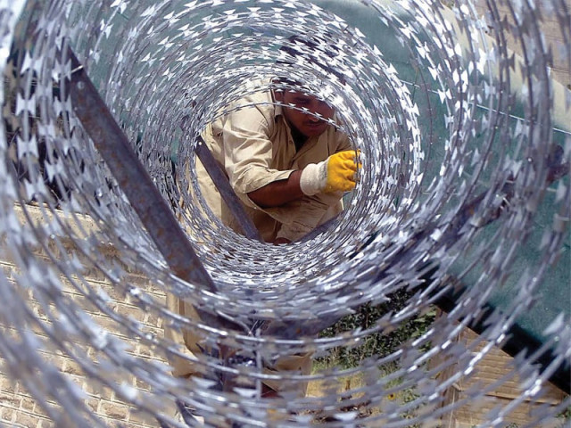 a worker installs barbed wire fencing around the boundary walls of the sardar bahadur khan women university in quetta photo inp a worker installs barbed wire fencing around the boundary walls of the sardar bahadur khan women university in quetta photo inp