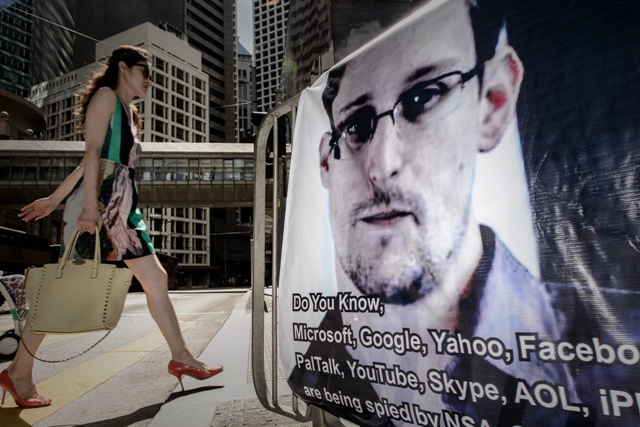 this file picture shows a woman walking past a banner displayed in support of former us spy edward snowden in hong kong photo afp file