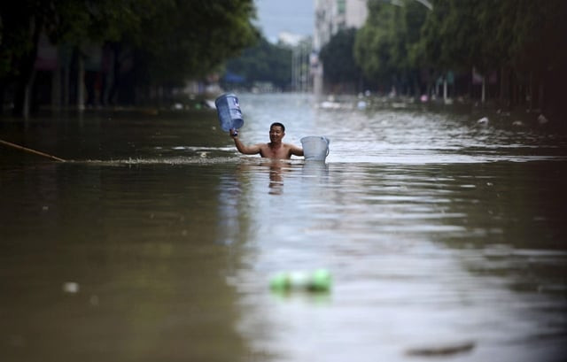 a man holds buckets as he wades through floodwater along a street in jintang county chengdu sichuan province july 11 2013 china braced on friday for the impact of typhoon soulik as the toll of dead and missing from torrential rain across a broad swathe of china climbed beyond 200 photo reuters a man holds buckets as he wades through floodwater along a street in jintang county chengdu sichuan province july 11 2013 china braced on friday for the impact of typhoon soulik as the toll of dead and missing from torrential rain across a broad swathe of china climbed beyond 200 photo reuters